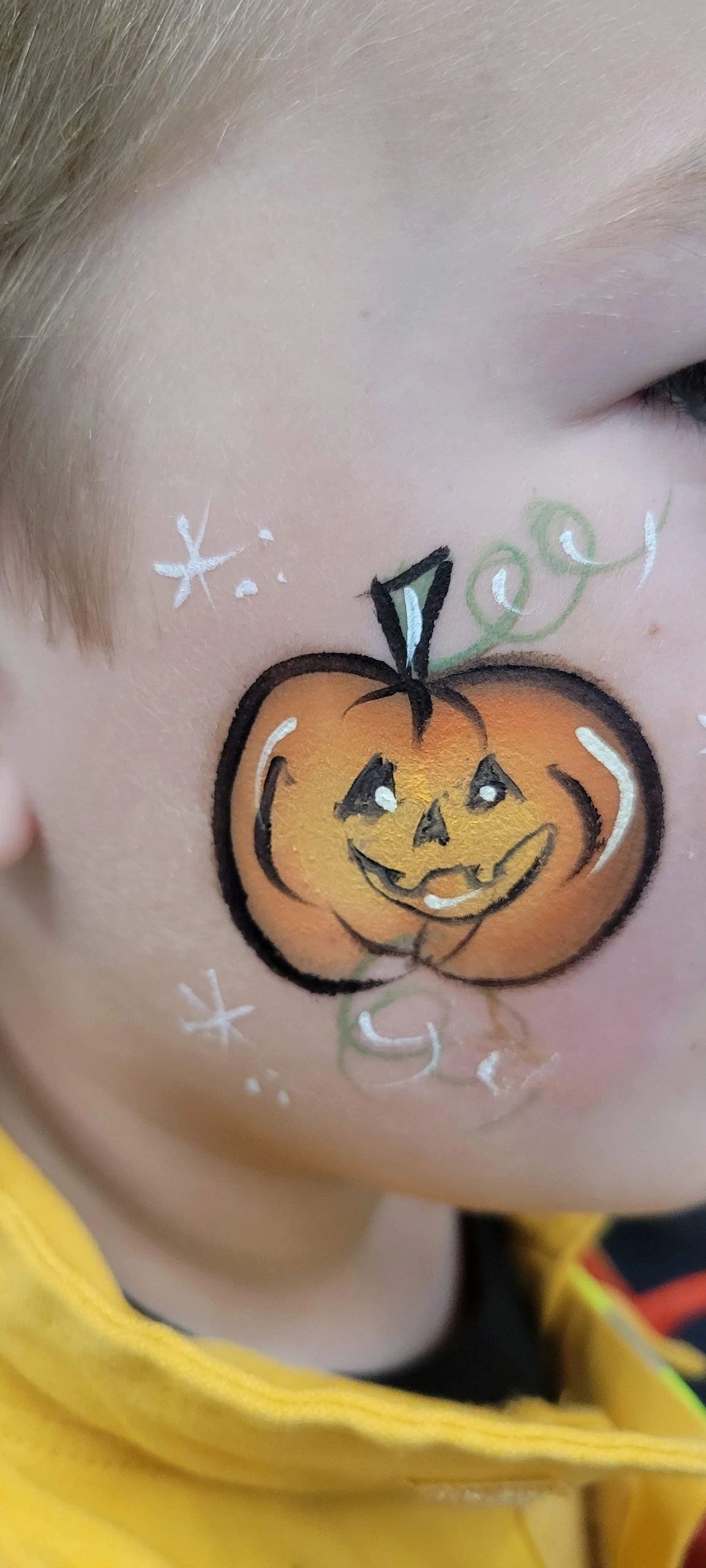 Child with Halloween pumpkin face paint