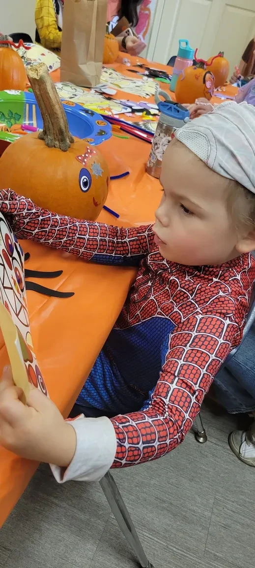 Child at Halloween pumpkin craft activity