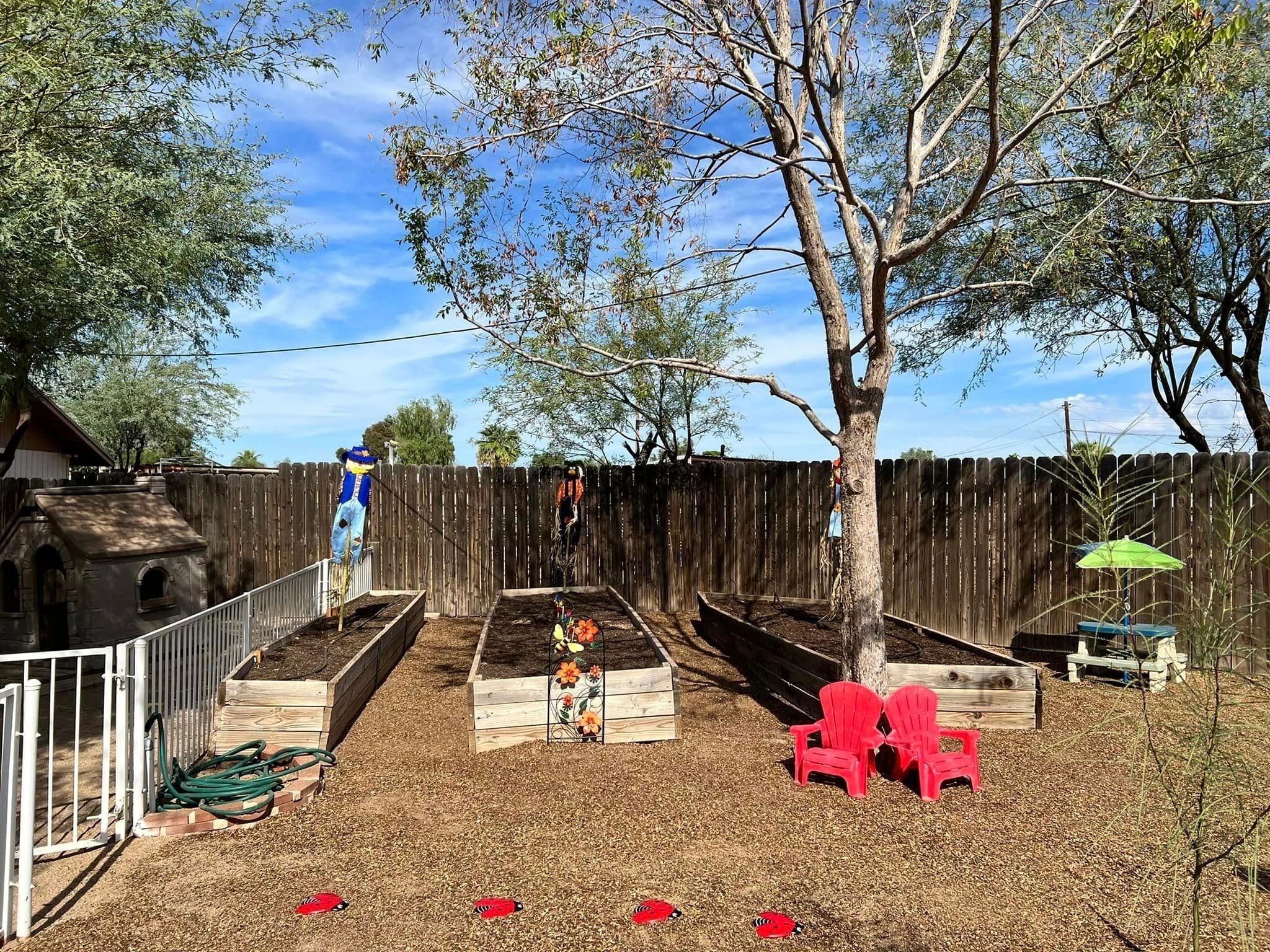School backyard garden with raised beds and red chairs