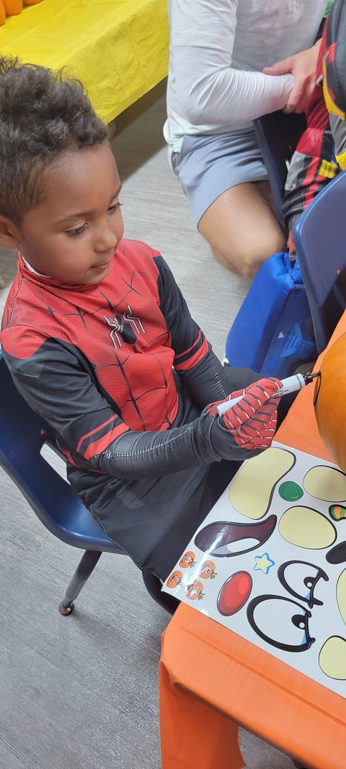 Child in Spider-Man costume playing classroom game