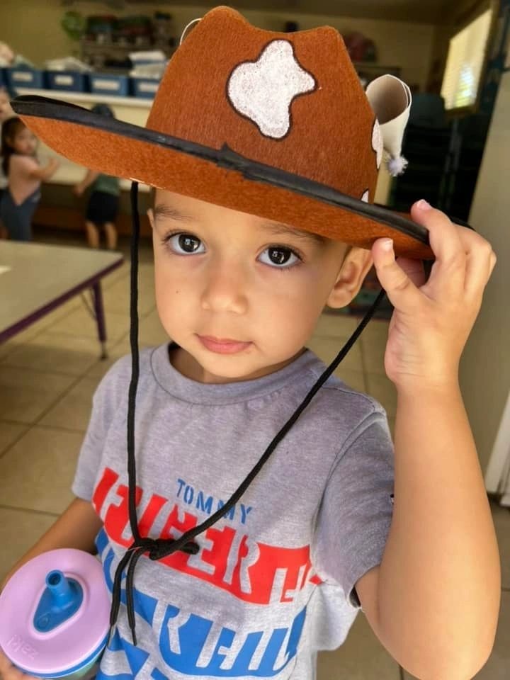 Child wearing handmade cowboy hat in classroom