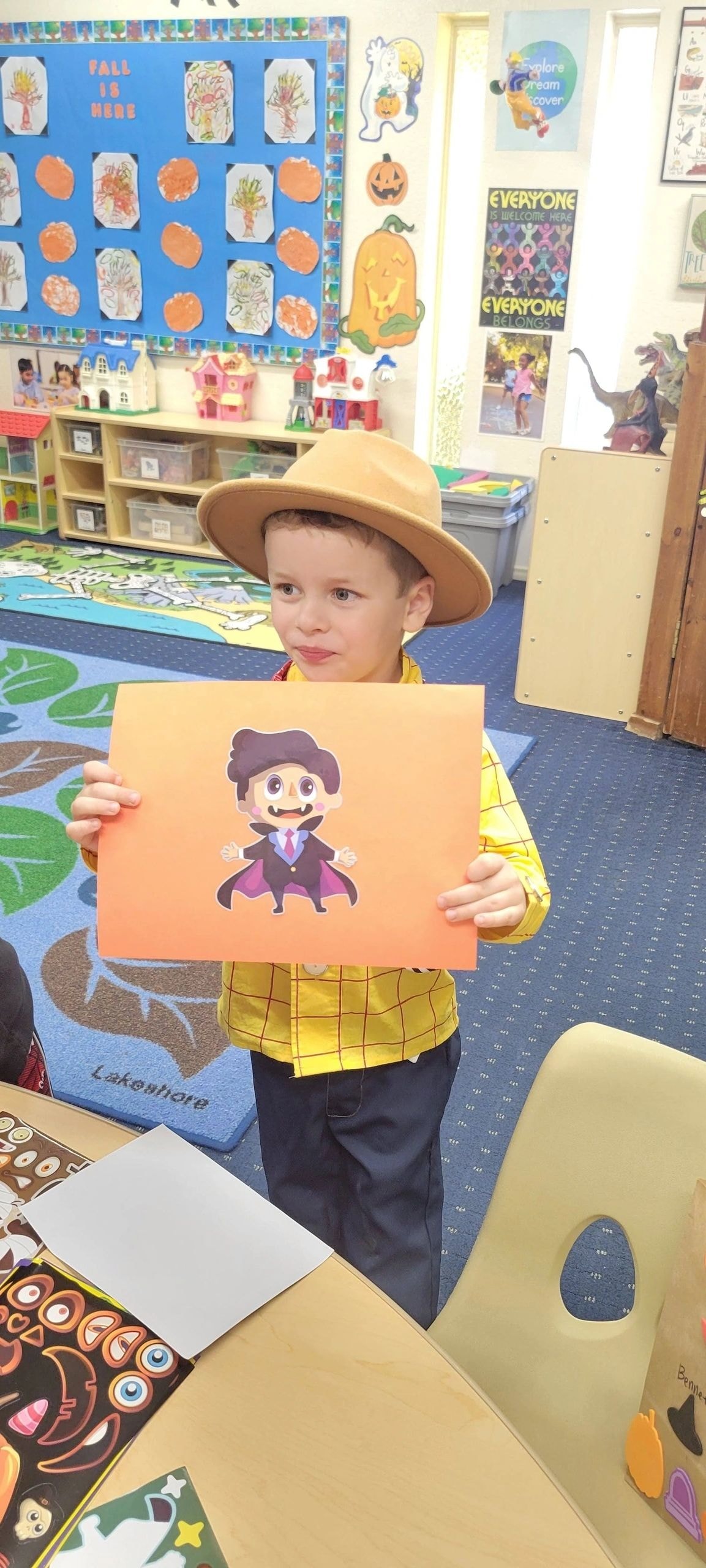 Child in cowboy costume holding Halloween artwork